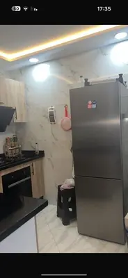 a kitchen with a stainless steel refrigerator in the corner at عمارة المودة 2 in Oulad Akkou