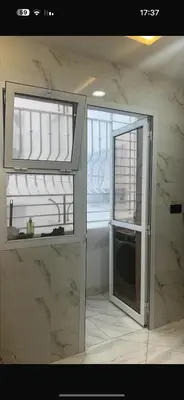 a kitchen with two windows and a microwave at عمارة المودة 2 in Oulad Akkou