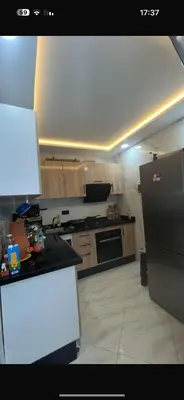 a kitchen with a refrigerator and a counter top at عمارة المودة 2 in Oulad Akkou