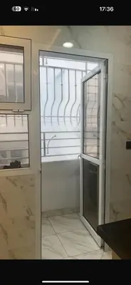 a kitchen with a glass door and a refrigerator at عمارة المودة 2 in Oulad Akkou