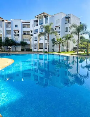 a large swimming pool in front of a building at Assilah in Oulad Akkou