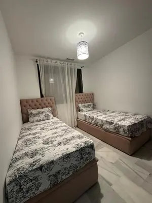 a bedroom with two beds and a chandelier at Assilah in Oulad Akkou