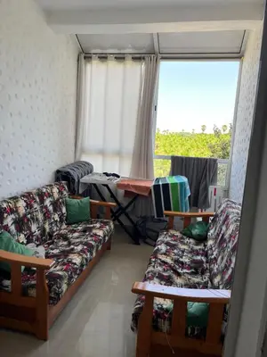 a living room with couches and a large window at Assilah in Oulad Akkou