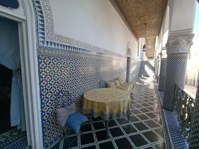 a room with a table and blue and white tiles at Suite in a 19 century palace in the heart of Medina in Fès