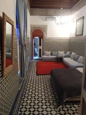 a bedroom with two beds and a red rug at Suite in a 19 century palace in the heart of Medina in Fès