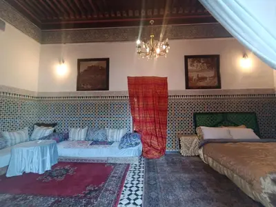 a bedroom with two beds and a chandelier at Suite in a 19 century palace in the heart of Medina in Fès