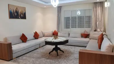 a living room with a white couch and a table at Prestige house in Oulad Akkou