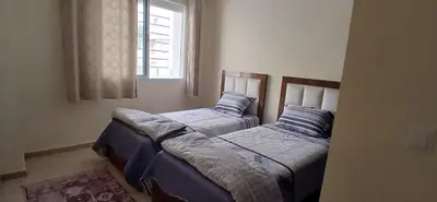 two beds in a room with a window at Prestige house in Oulad Akkou