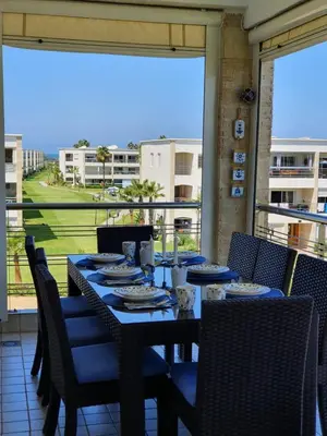 a table on a balcony with a view of the ocean at Le bleu d Olablanca in Zaouia Sidi Rahkal