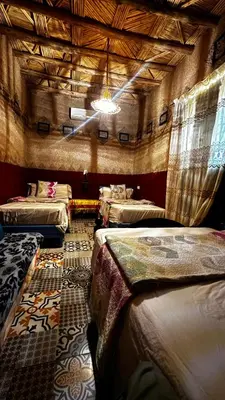 a room with three beds in a building with a ceiling at Hostel Khamlia in Khamliya