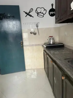 a kitchen with a door in the corner of a room at Social appartement at Martil in Oulad Akkou
