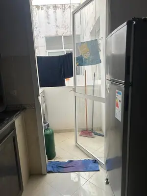 an open door to a kitchen with a refrigerator at Social appartement at Martil in Oulad Akkou