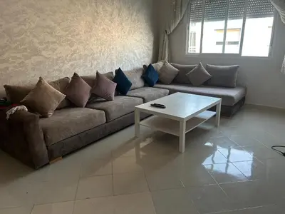 a living room with a couch and a coffee table at Social appartement at Martil in Oulad Akkou