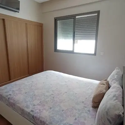 a bedroom with a large bed and a window at Vacation apartment in Oulad Akkou
