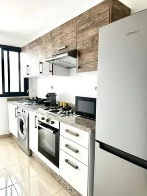 a kitchen with a stove and a refrigerator at Appartment central view on Hassan II in Oulad Akkou