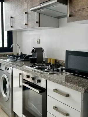 a kitchen with a stove top oven next to a sink at Appartment central view on Hassan II in Oulad Akkou