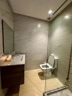 a bathroom with a toilet and a glass shower at Appartment central view on Hassan II in Oulad Akkou