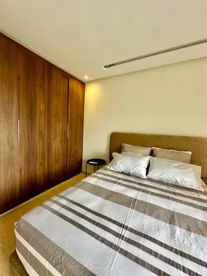 a bedroom with a large bed with wooden cabinets at Appartment central view on Hassan II in Oulad Akkou