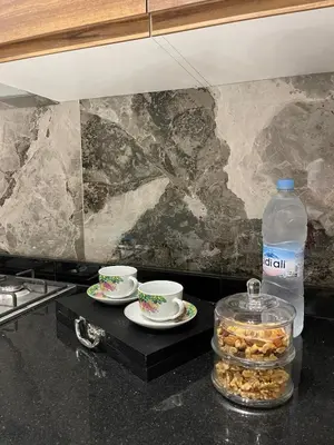 a kitchen counter with two cups and a bottle of water at Prestige Apartment in Fès