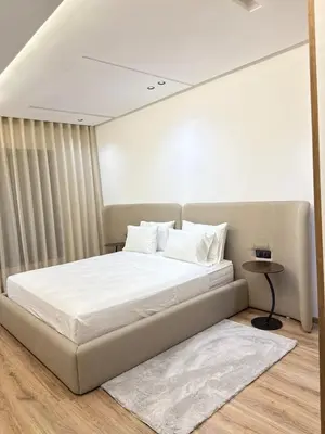 a bed with white sheets and pillows in a room at Prestige Apartment in Fès