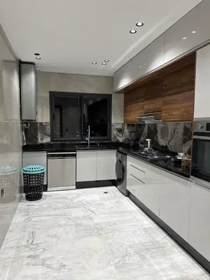 a large kitchen with black and white appliances at Prestige Apartment in Fès