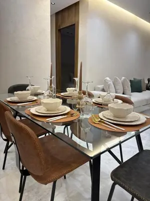 a dining room table with plates and glasses on it at Prestige Apartment in Fès