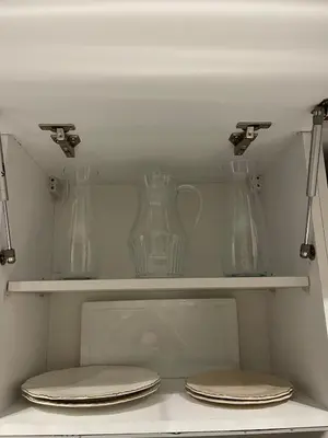 three glass vases sitting on shelves in a refrigerator at Prestige Apartment in Fès