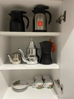 a cupboard filled with pots and pans and tea sets at Prestige Apartment in Fès