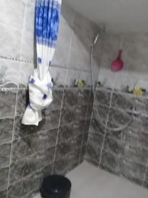 a shower in a bathroom with a shower head at appartement meuble in Oulad Akkou