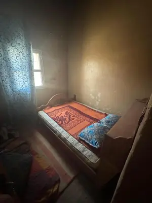 a small room with a bed and a window at Merzouga in Merzouga