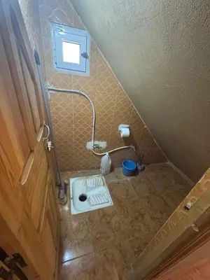 a small bathroom with a toilet in the floor at Merzouga in Merzouga