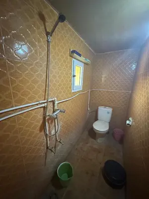 a small bathroom with a toilet and a shower at Merzouga in Merzouga