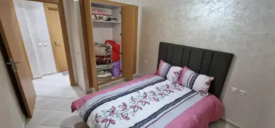 a bed with pink and white sheets in a bedroom at Bahia Sakan in Oulad Akkou