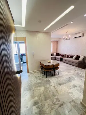 a living room with a table and a couch at Luxury Appartement fes city fleur in Fès