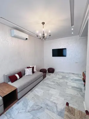 a living room with a couch and a flat screen tv at Luxury Appartement fes city fleur in Fès