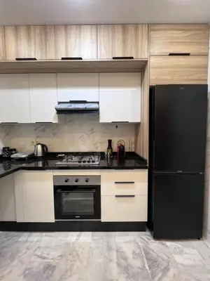 a kitchen with a stove and a black refrigerator at Luxury Appartement fes city fleur in Fès