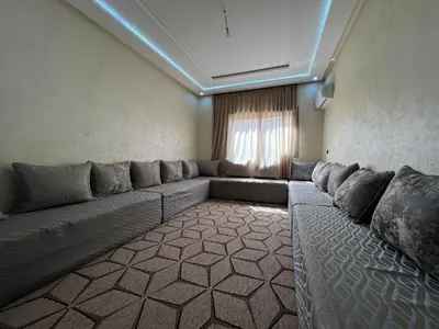 a living room with a long couch in a room at Modern and quiet apartment in Beni Mellal