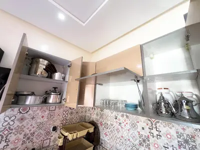 a kitchen with pink and white tiles on the wall at Modern and quiet apartment in Beni Mellal