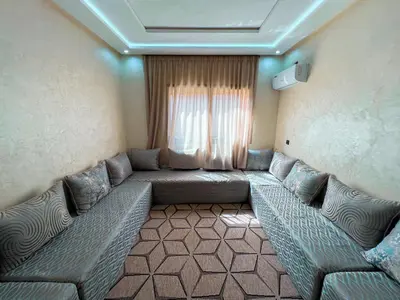 a living room with couches in front of a window at Modern and quiet apartment in Beni Mellal