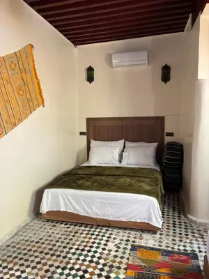 a bedroom with a bed and a tiled floor at Riad Serendipity in Fès