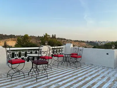 a group of chairs and tables on a balcony at Riad Serendipity in Fès