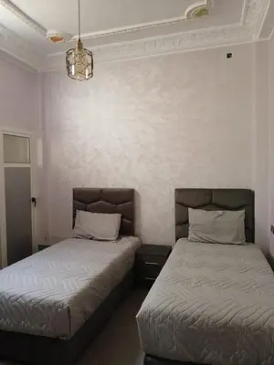 two beds sitting next to each other in a bedroom at إقامة الخال للشقق المفروشة الرشدية in Er Rachidia