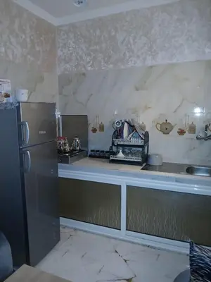a kitchen with a refrigerator and a counter top at إقامة الخال للشقق المفروشة الرشدية in Er Rachidia