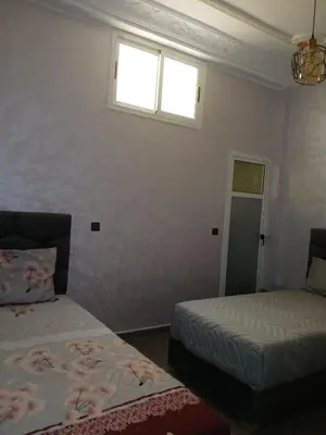 a bedroom with two beds and a window at إقامة الخال للشقق المفروشة الرشدية in Er Rachidia