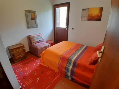 a bedroom with a bed and a chair in it at Centrical apartment in Ifrane forest and park view in Ifrane