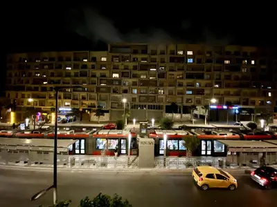 a car parked in a parking lot in front of a building at cosy appartement calme in Oulad Akkou