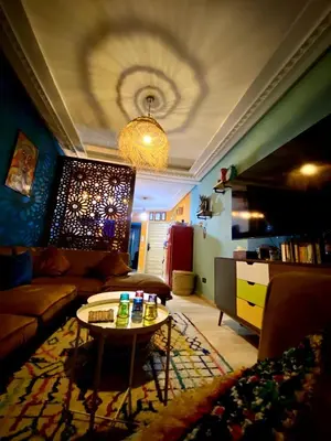 a living room with a couch and a table at cosy appartement calme in Oulad Akkou