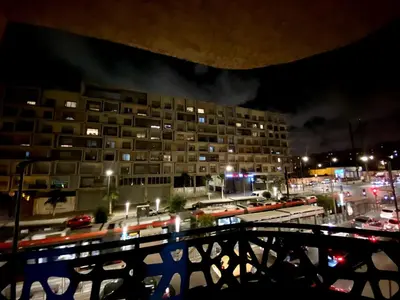 a view of a building at night with traffic at cosy appartement calme in Oulad Akkou