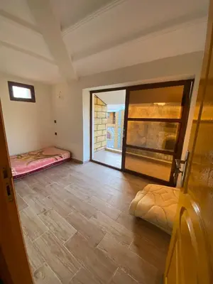 a room with two beds and a large window at Maison villa in Oulad Akkou