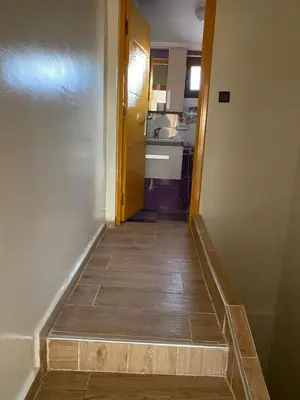 a stairway leading to a kitchen and a hallway with a door at Maison villa in Oulad Akkou